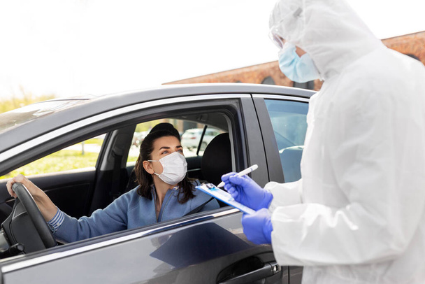 healthcare worker with clipboard and woman in car - Foto, Bild