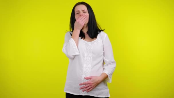 Sick pregnant woman coughs covering mouth with palm, holds stomach with hand - Footage, Video