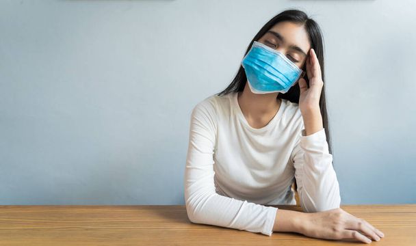 Les femmes asiatiques portent un masque tiennent leur tête à cause de maux de tête. Elle a de la fièvre et de la migraine en raison du stress ou du sommeil tardif, d'un faible sommeil, d'un repos insuffisant dans un concept sain avec espace de copie
 - Photo, image