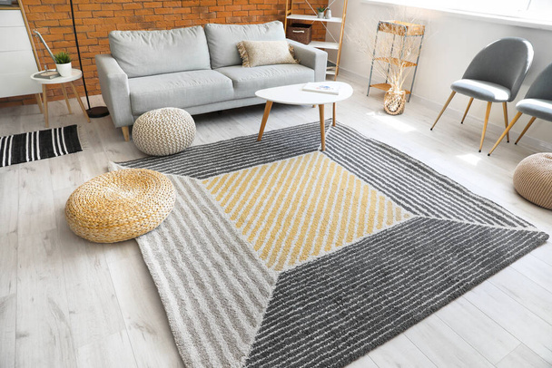 Стильний інтер'єр вітальні з килимом і диваном
 - Фото, зображення