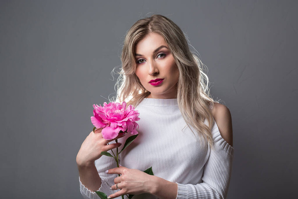 Beautiful young woman with pink peonies. beauty, spa and body care concept. - Foto, Imagen