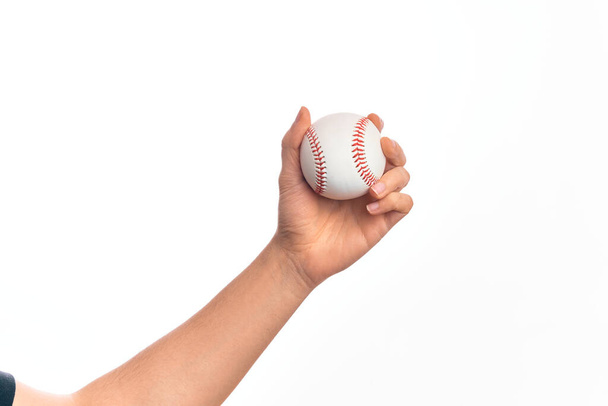 Beyzbol topunu izole edilmiş beyaz arka planda tutan beyaz bir adamın eli. - Fotoğraf, Görsel