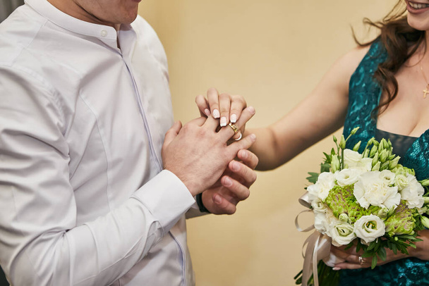 Bruid die een trouwring om de vinger van de bruidegom doet - Foto, afbeelding