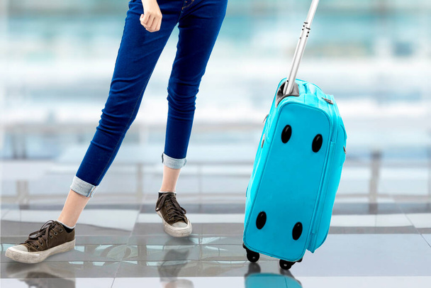 Die Frau steht mit einem Koffer auf dem Flughafen - Foto, Bild