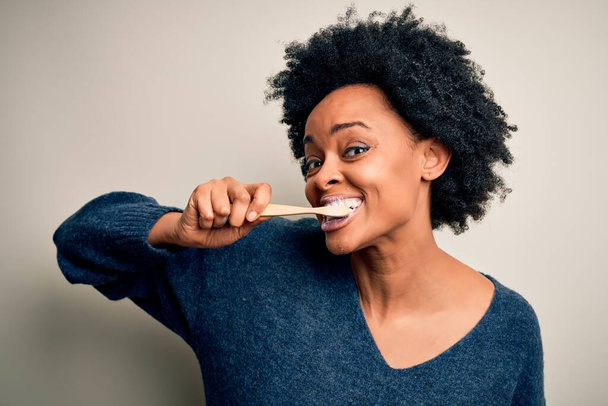 Donna afroamericana lavarsi i denti con spazzolino da denti e pasta orale, pulizia dei denti e della lingua come routine sanitaria sana mattina - Foto, immagini