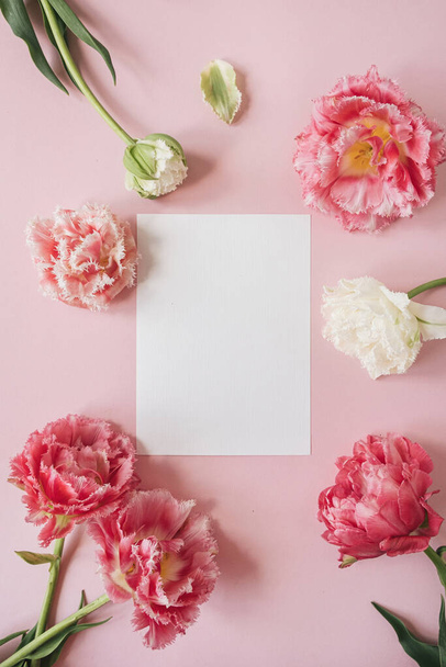 Üres papír lap keret rózsaszín és fehér bazsarózsa tulipán virágok. Lapos fekvésű, felülnézet - Fotó, kép