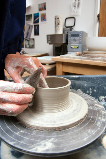 A lady ceramics artist at work in her home pottery studio, - Photo, Image