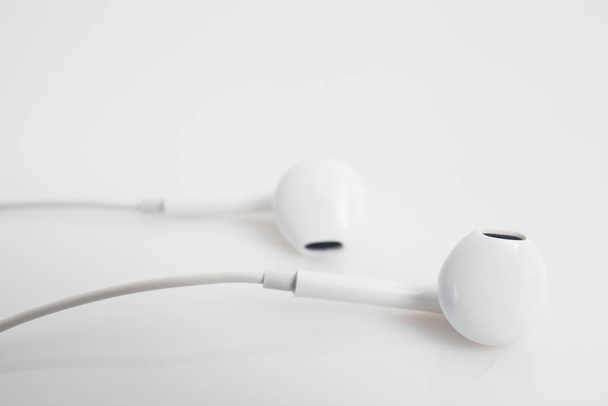 White ear buds against a white background - Foto, immagini
