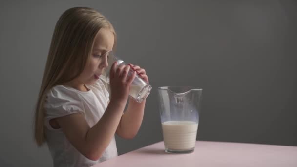 boční pohled Kavkazská malá dívka nápoje mléko ze sklenice, - Záběry, video