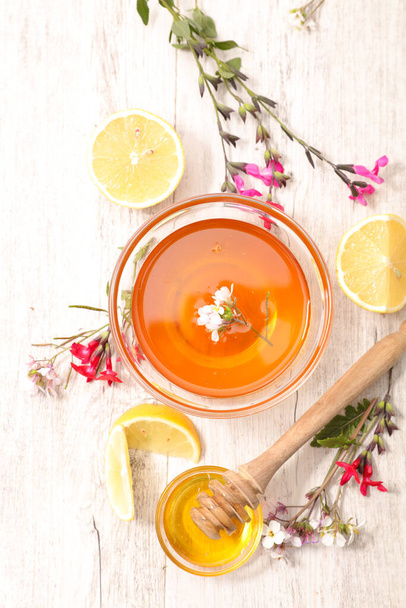 honey with lemon, flower and spoon - Photo, Image