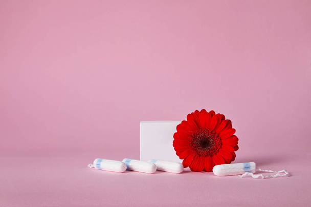 menstrual tampons and red flower isolated on pink background, top view. copy space - Fotografie, Obrázek