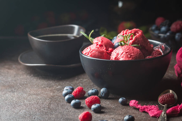 Homemade berry ice cream in a black bowl on a rustic background. - Фото, зображення