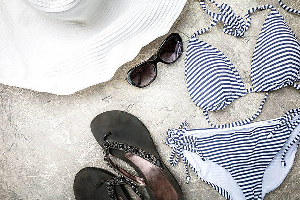 Verão feminino biquíni listrado maiô, roupas e acessórios coleção em fundo cinza. Deitado plano, vista superior - Foto, Imagem
