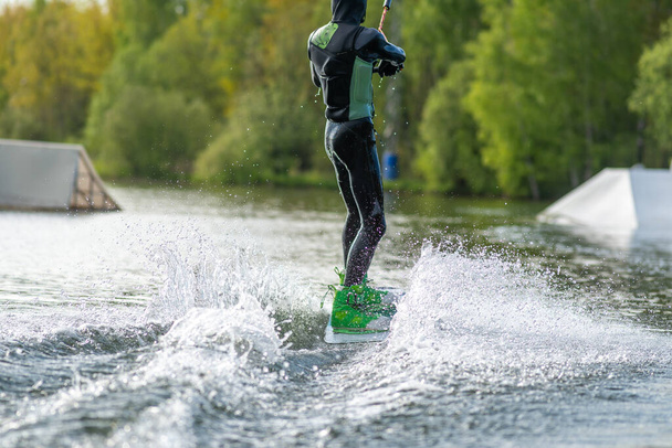 Wakeboarder fait des tours. Plan à angle bas de l'homme wakeboarding sur un lac
. - Photo, image