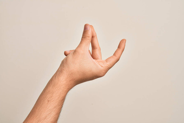 Mano de joven caucásico mostrando los dedos sobre el fondo blanco aislado chasquidos dedos para el éxito, fácil y haga clic en gesto símbolo con la mano - Foto, Imagen