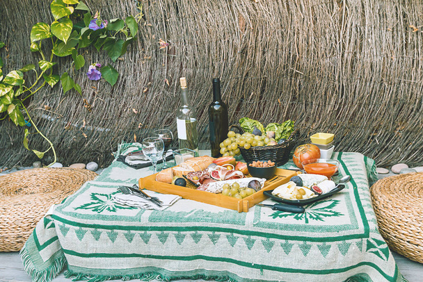 Plato antipasti italiano con jamón, salami, quesos, aceitunas e higos y vino - Foto, Imagen