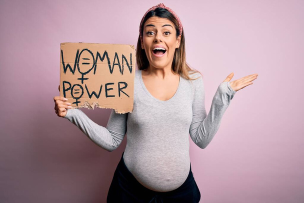 Genç esmer kadın hamile, bebek pankartı bekliyor. Kadın gücü istiyor. Çok mutlu ve heyecanlı. - Fotoğraf, Görsel