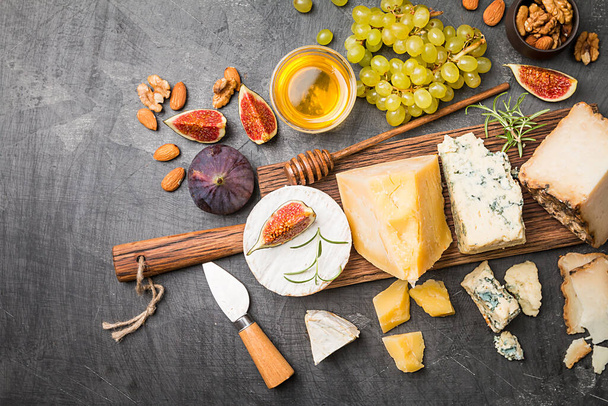 various types of cheese on wooden cutting board, top view - Foto, Imagen