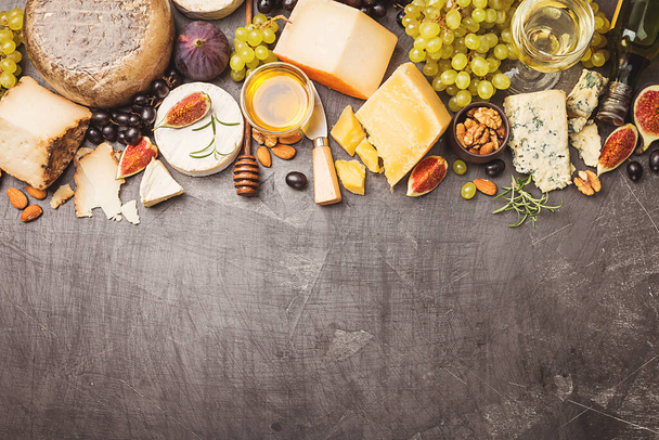 various types of cheese on wooden cutting board, top view - Foto, afbeelding