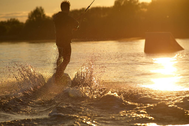 Wakeboarder fait des tours. Plan à angle bas de l'homme wakeboarding sur un lac
. - Photo, image