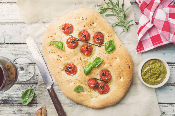 Traditional Italian Focaccia with tomatoes and rosemary - homemade flat bread focaccia over wooden background, top view - Photo, Image