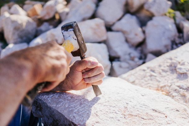Sculpteur en pierre travaillant avec marteau et ciseau
 - Photo, image