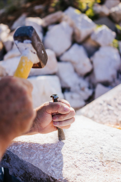 Кам'яний різьбяр, що працює з молотком і стамескою
 - Фото, зображення