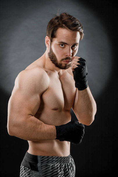 Retrato de un boxeador con vendajes en las manos. Puños de un luchador antes de una pelea o entrenamiento en el gimnasio. El concepto de deporte. - Foto, imagen