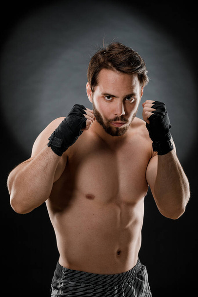 Retrato de un boxeador con vendajes en las manos. Puños de un luchador antes de una pelea o entrenamiento en el gimnasio. El concepto de deporte. - Foto, Imagen