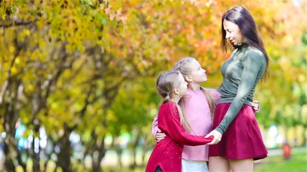 Rodina matky a dětí na podzim. Mladá matka a malé dívky si užívají teplý podzim - Záběry, video
