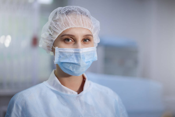 Χειρουργική νοσοκόμα με καπέλο και μάσκα στην ιατρική κλινική. Κοντινό πορτραίτο. Υγεία, χειρουργική επέμβαση. - Φωτογραφία, εικόνα