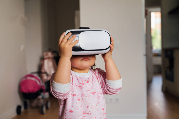 Toddler girl with vr glasses at home. Learning, watching movie, playing games. Future technologies - Valokuva, kuva