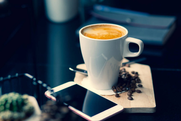 Горячий кофе на деревянном подносе в кафе, винтажный тон стиль и оранжевый свет утром Горизонтальное изображение - Фото, изображение