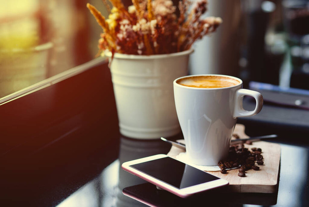 Горячий кофе на деревянном подносе в кафе, винтажный тон стиль и оранжевый свет утром Горизонтальное изображение - Фото, изображение