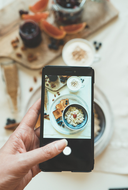 Woman doing photo of morning breakfast on mobile phone. - Photo, Image