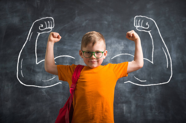 Funny kid with strong arms drawn on blackboard. Back to school - Foto, Imagen