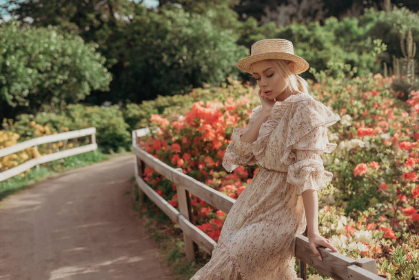 Giovane bella donna nel parco. ritratto di moda. donna bionda con vestito beige e cappello di paglia. concetto estivo. donna felice godendo la natura
 - Foto, immagini