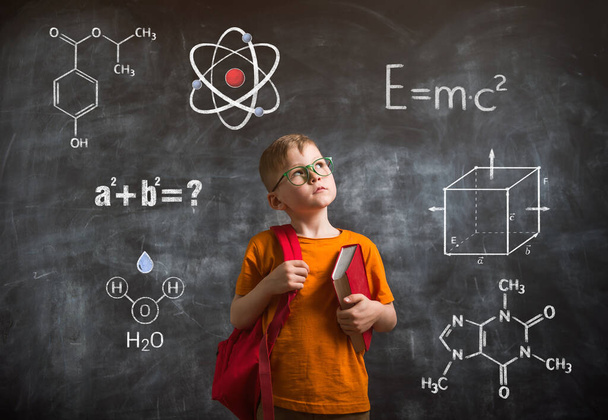 Kid thinking with formula on blackboard. Back to school. Smart little boy. - Foto, Imagen