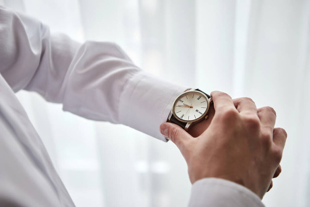 businessman checking time on his wrist watch, man putting clock on hand,groom getting ready in the morning before wedding ceremony. Men Fashion - Zdjęcie, obraz