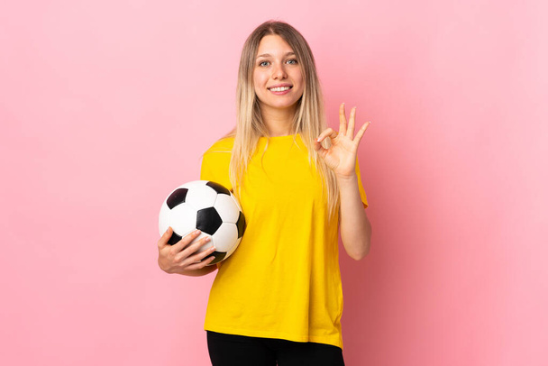 Jeune footballeuse femme isolée sur fond rose montrant un signe ok avec les doigts
 - Photo, image