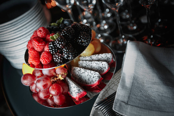 Berries and fruits in a vase on the table. Hight quality photo - Foto, Bild