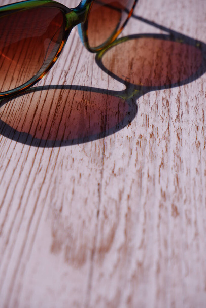 Aurinkolasit heijastuvat puupohjalle kirkkaana päivänä - Valokuva, kuva