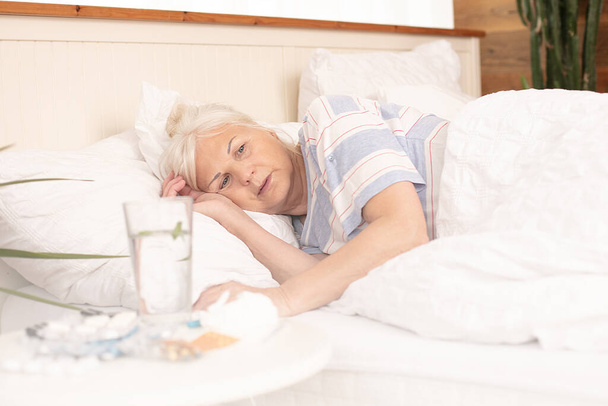 Seasonal flu. Sick senior woman with fever in bed, at home. - Fotoğraf, Görsel