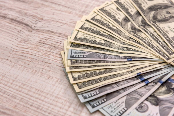 Billetes de dólar en abanico sobre mesa de madera de cerca
 - Foto, Imagen