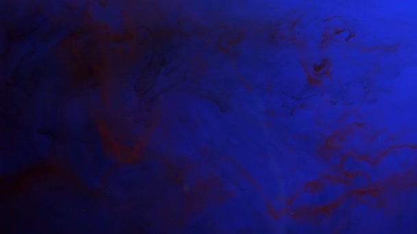 Tinta roja oscura mezclada en agua, girando suavemente bajo el agua sobre fondo azul
 - Metraje, vídeo