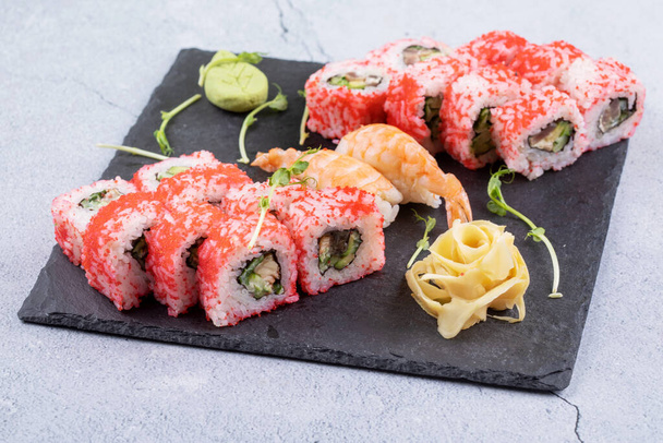 Sushi Set sashimi és sushi tekercs felszolgált kő pala - Fotó, kép