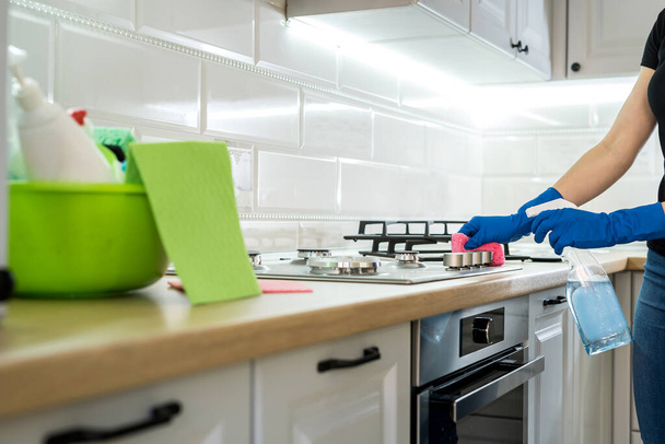 Evdeki mutfakta lastik eldiven ve süngerle temizlik yapan genç bir kadın.. - Fotoğraf, Görsel