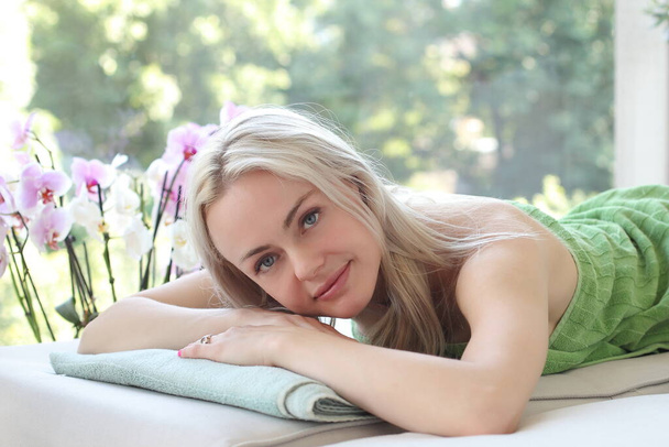 Donna attraente e sorridente sdraiata sul tappeto da massaggio
 - Foto, immagini
