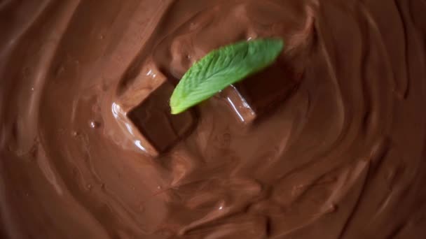 mintunlehdet putoavat sulatettuun suklaaseen, hidastettu lähikuva laukaus - Materiaali, video