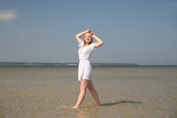 Щаслива молода дівчина в білій сукні біля моря
 - Фото, зображення
